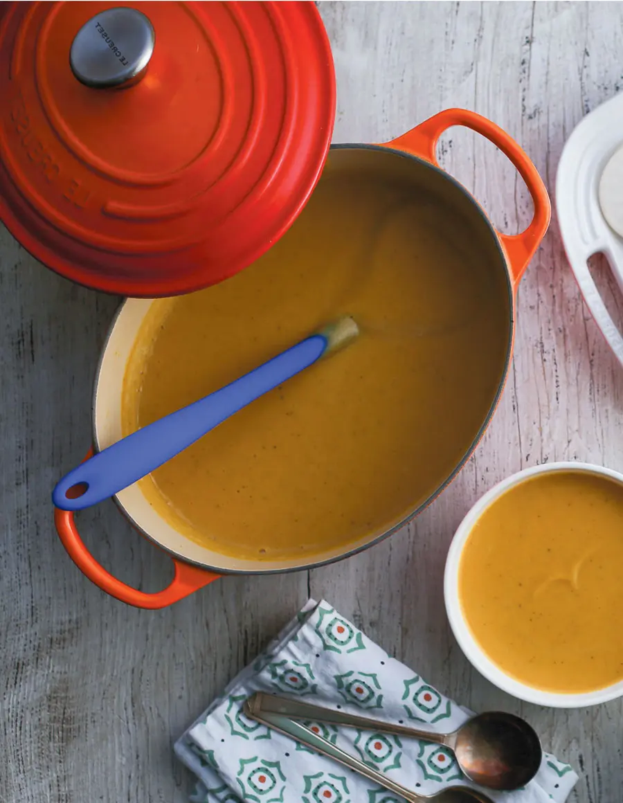 A red Le Creuset pot full of nourishing pumpkin soup