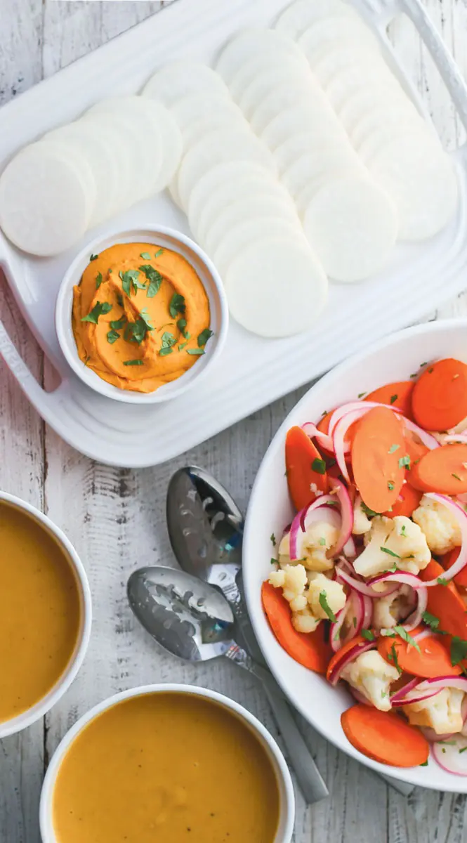 a table of sweet potato hummus and fresh vegetables